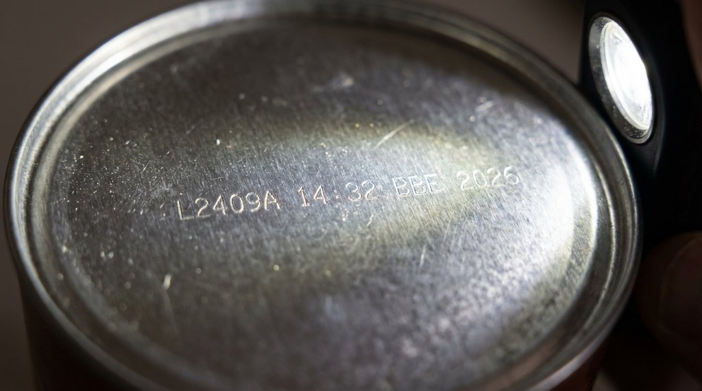 Close-up of a coffee can bottom showing laser-etched lot code